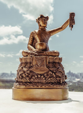 Bronze figurine of Phra upagupta or Phra bua khem statue with nature background. Selective focus.