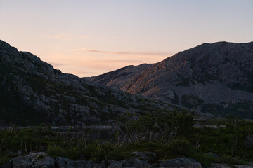 Sunset behind lake between mountains