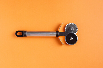 A special pizza knife on an orange background.