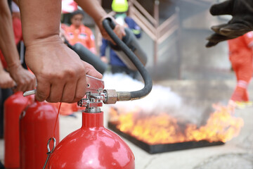 Employees firefighting training, Concept Employees hand using fire extinguisher fighting fire...