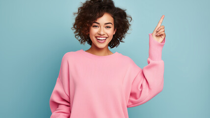 young smiling happy woman of Asian ethnicity 20s in pink sweater point finger on big mobile cell phone