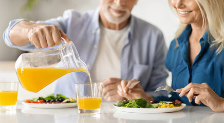 Happy Mature Couple Eating Tasty Breakfast In Kitchen At Home