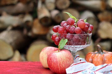 Vibrant still life with grapes and apples on textured red background with space for text. Healthy eating concept. 