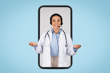 Friendly brazilian woman doctor in huge smartphone screen gesturing and smiling at camera, having online appointment