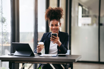 African american businesswoman in suit holding coffee cup and reading accounting information of new business