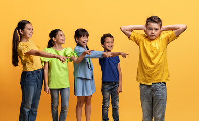 Obraz premium Angry cruel teenagers laughing at their classmate, yellow background