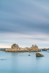 Fototapeta na wymiar rocks in the blue sea in cloudy weather