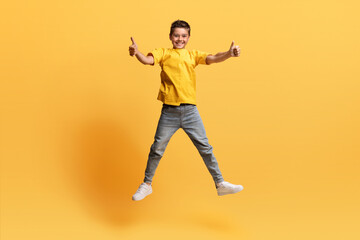 Fototapeta na wymiar Cute preteen cheerful boy jumping in the air