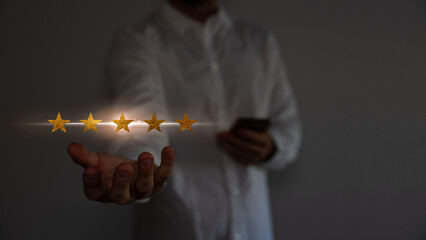 Concept of satisfaction and customer service. Business man holding the virtual screen the five star to show satisfaction or the service or give rate. 