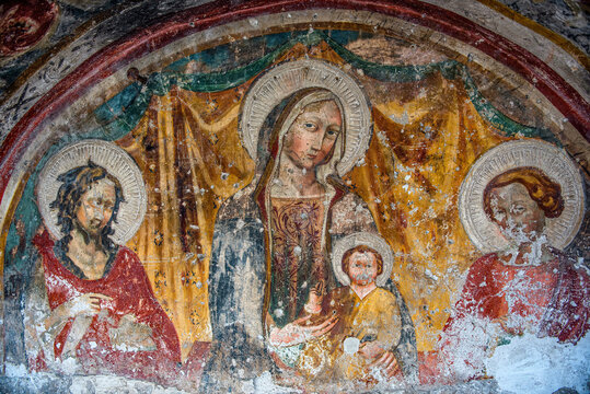 15th-century fresco of the Umbrian school depicting the virgin with child and figures of saints in the ancient Via della Spina in Silvignano, Spoleto, Umbria, Italy , 10 November 2017