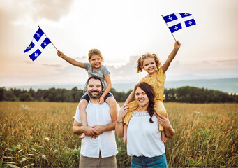 A Patriotic family waving Quebec flags on sunset