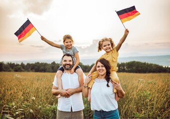 A Patriotic family waving Germany flag on sunset