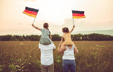 A Patriotic family waving Germany flag on sunset