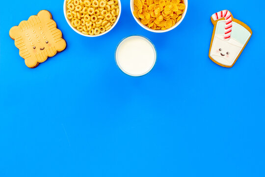 Flat lay of food for kids - milk with cornflakes and biscuits, top view