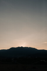 Sun setting behind Flag Peak mountain and darkening the mountains.
sunset in the mountains.