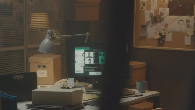 No people shot of workplace of professional police detective in office with suspects data base on desktop computer and investigation corkboard on wall