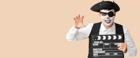 Man dressed for Halloween as pirate with clapperboard on beige background with space for text
