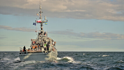 Fototapeta premium Okręt wojenny płynący na morzu przed zachodem słońca