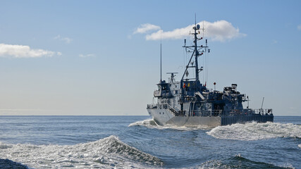 Fototapeta premium Okręt wojenny płynący na morzu w słoneczny dzień