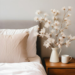 Comfortable bedroom with minimalist decor, bed, pillows, flowering plant, and white vase