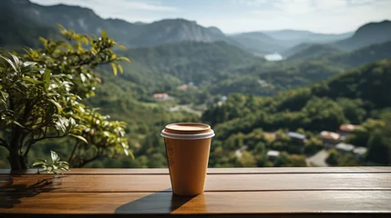 Rolgordijnen Coffee cup placed in hand against beautiful cool mountain landscape background © MBRAMO