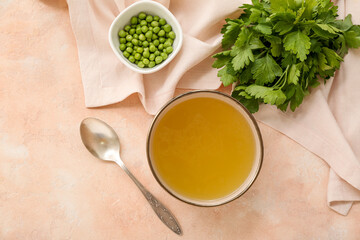 Bowl of tasty vegetable broth on beige background
