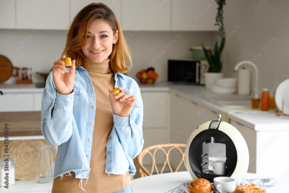 Wall mural young woman with capsules and coffee machine in kitchen