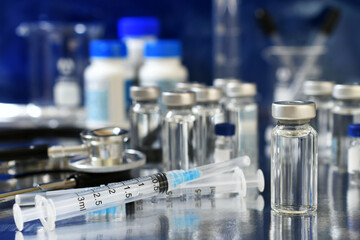 Vaccine booster tripledemic concept background - vials of generic vaccines with syringe and...
