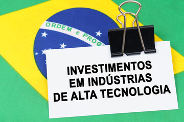 On the flag of Brazil lies a business card with the inscription - investments in high-tech industries