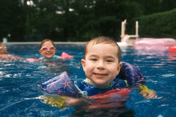 Young Boy Enjoying the Pool with Swimmies