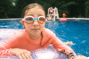 Young girl enjoying swimming pool wearing goggles