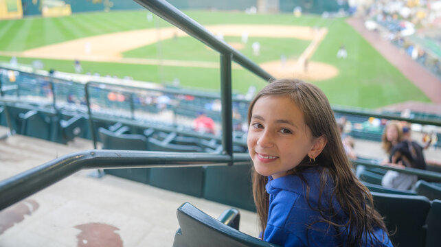 Young girl smiling baseball stadium fan, opening day, spring training, family fun activities