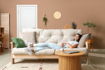 Young woman lying on couch in living room