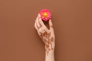 Tuinposter Female hand with lotus flower for celebration of Divaly on brown background © Pixel-Shot
