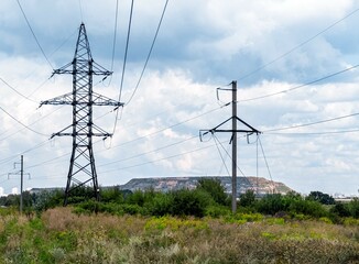 Electric energy transmission towers, masts with cable lines in nature