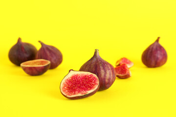 Fresh juicy cut figs on yellow background