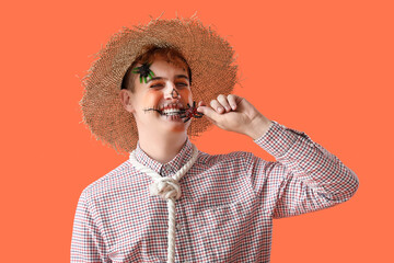Young man dressed for Halloween eating candy on red background