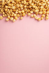 Film Buff's Dream: Vertical top view of mouthwatering popcorn on a pastel pink surface, space available for text or adverts