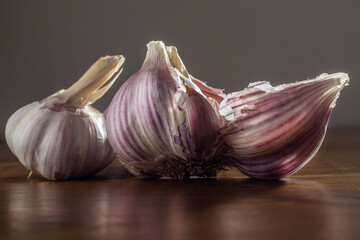 Algumas cabeças de alho sobre uma superfície de madeira reluzente.