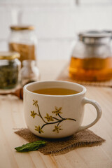Obraz na płótnie Canvas close up of ceramic mug tea with hand painted flowers 