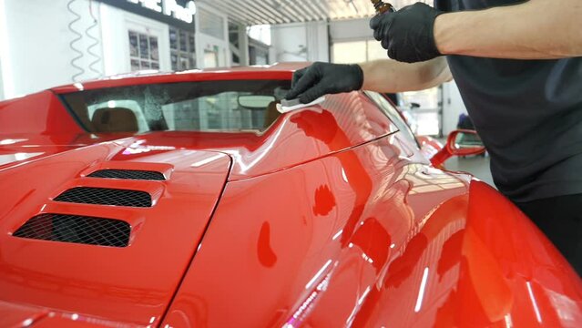 Staff wear Chemical protective clothing at work. Automobile industry. Car wash and coating business with ceramic coating.Spraying the varnish to the car. Concept of: Car protective, Service, Shine.	

