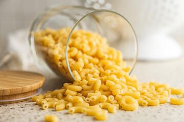 Raw macaroni pasta in glass bottle. Uncooked rigatoni in glass jar.