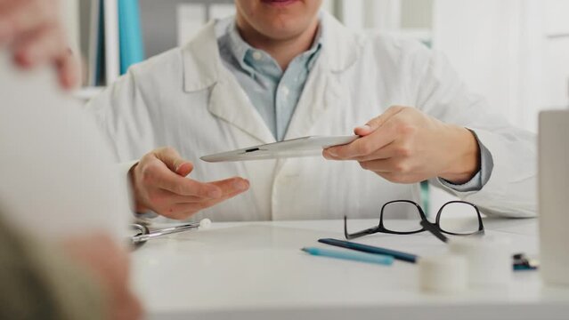 Gynecology. A medical specialist in a doctor's clinic uniform works at a desk in a doctor's office. Young male specialist writes data information conducts proven diagnostic methods, visit to doctor