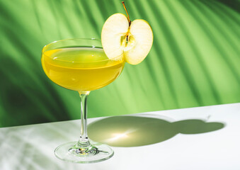 Apple pie alcoholic cocktail beverage with vodka, apple liqueur, cinnamon syrup.. Light green background, hard light, shadow pattern