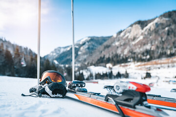 Close up of skis, ski goggles, ski gloves and ski poles. Sports equipment displayed in snow with...