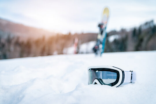 Close up of ski goggles in snow. Winter Alpine scenery with sport equipment.