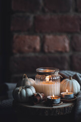 Autumn home composition with aromatic candle, dry citrus, cinnamon, anise. Aromatherapy on a grey fall morning, atmosphere of cosiness and relax. Wooden background close up copy space