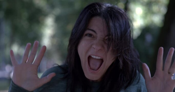 Funny woman reacting with surprise and shock to camera in super slow-motion 800 fps. Exaggerated reaction of person yelling at camera