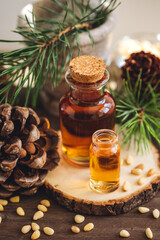 Organic essential oil, pine nuts, cedar cone on rustic wooden dark background. Concept of natural ingredients, naturopathy, herbal extracts and essence. Alternative medicine, aromatherapy
