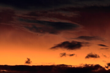 cloud silhouettes floating under a twilight sky.